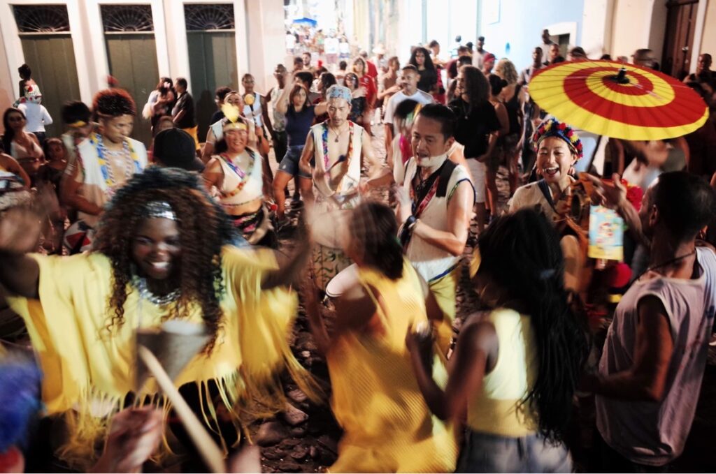 ブラジルでのパレードを率いる、佐藤ユミ。赤と黄色の渦模様の傘が目を引く。